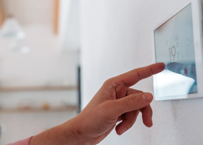 Close,Up,Of,Smart,Thermostat,,Adjusting,,Lowering,Heating,Temperature,At